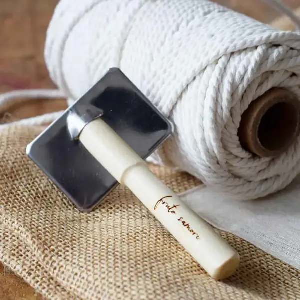 Cepillo macramé junto a bobina de hilo